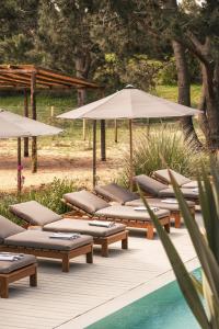 a row of lounge chairs and umbrellas next to a pool at Posada Arenas in José Ignacio +7 photos