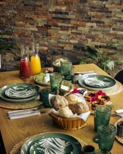 a wooden table with plates of food on it at Portugal Alma - Oporto Guesthouse in Ermesinde +20 photos