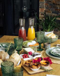 a table topped with plates of food and juice at Portugal Alma - Oporto Guesthouse in Ermesinde