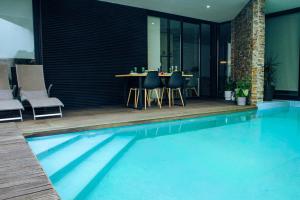 a swimming pool with a table and chairs in a house at Portugal Alma - Oporto Guesthouse in Ermesinde