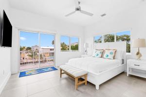a white bedroom with a bed and a window at Surfstream Edge in Marathon Airport
