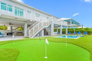 a house with a putting green and a pool at Surfstream Edge in Marathon Airport