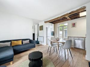 ein Wohnzimmer mit einem blauen Sofa und einem Tisch in der Unterkunft pleasant old and comfortable little house in Apremont