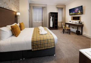 a hotel room with a large bed and a desk at New Town Hotel in Edinburgh +15 photos