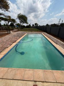 a swimming pool with a hose in the water at GlowtiAirbnb in Centurion