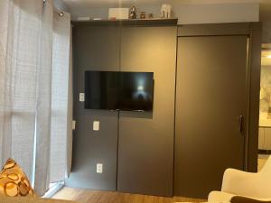 a living room with a tv on a wall at Allianz Vila Romana in São Paulo