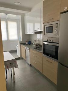una cocina con estufa y microondas en Precioso apartamento en A Coruña, en A Coruña