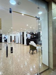 a glass door in a lobby with a chair at شقق طرابزون المخدومة in Rumāḩ