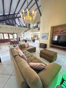 a large living room with couches and a chandelier at Recanto do Amor in Cascavel