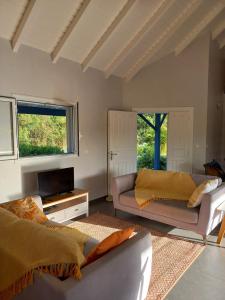 ein Wohnzimmer mit Sofa und Fernseher in der Unterkunft Villa Blue Sky in Saint-François + 33 Fotos