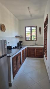Safina Cottages في شاطئ دياني: مطبخ مع خزائن خشبية وطاولة عمل