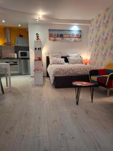 a living room with a bed and a kitchen at L'arc-en-ciel in Le Tréport