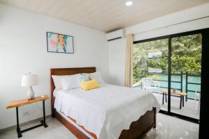 a bedroom with a bed and a balcony at Casa Ola Ini Studio Playa Grande in Playa Grande +16 photos