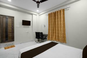 een slaapkamer met een bed, een bureau en een stoel bij HOTEL O CROWD in Durg