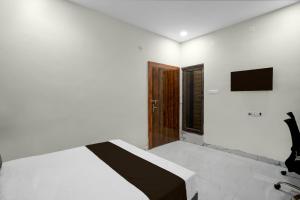 een slaapkamer met een bed en een televisie aan de muur bij HOTEL O CROWD in Durg