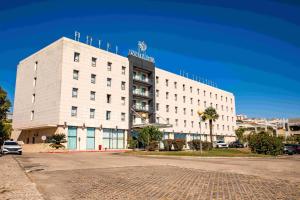 a white building with a sign on top of it at VIP Executive Santa Iria Hotel in Santa Iria da Azóia