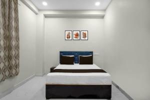 een slaapkamer met een bed met een blauw hoofdeinde bij HOTEL O CROWD in Durg +19 foto's