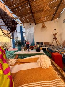 een woonkamer met twee bedden en een tafel bij Art Of Balance in Tamraght Ouzdar