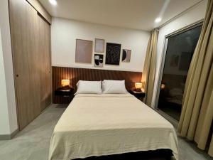 a bedroom with a large bed with two lamps on the side at Apartamento con vista,piscina y playa -SantaMarina-803 in Santa Marta