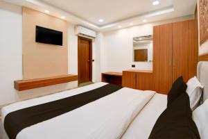 a bedroom with a bed and a tv on the wall at Hotel O THE SHAURYA INN in Bhauli +20 photos