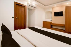a hotel room with a bed and a television at Hotel O THE SHAURYA INN in Bhauli