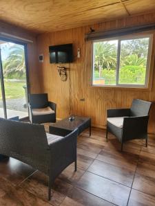 Una sala de estar con sillas, una mesa y un televisor. en La Rinconada Quillon, en Quillón