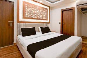a bedroom with a large white bed with black pillows at Hotel O THE SHAURYA INN in Bhauli