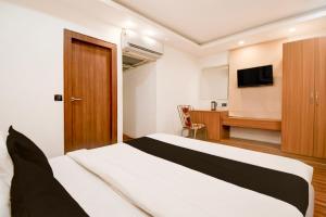 a hotel room with a bed and a television at Hotel O THE SHAURYA INN in Bhauli