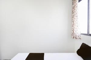 a bedroom with a black and white bed and a window at SPOT ON Ap Logde in Māharjhari