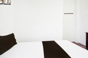 a black and white bed in a white room at SPOT ON Ap Logde in Māharjhari