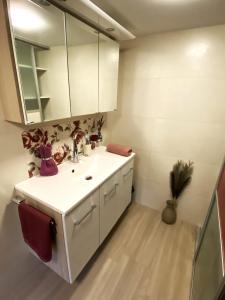 a white bathroom with a sink and a mirror at "Nestl" in Bad Häring +18 photos