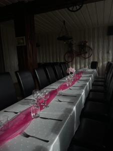 a long table with wine glasses and pink ribbon at Penzión Korytnačka in Námestovo