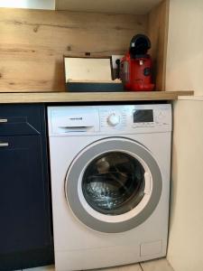a washing machine with a red appliance on a counter at T3 cozy Saint Genis Laval - balcony - quiet - HLS in Saint-Genis-Laval +12 photos