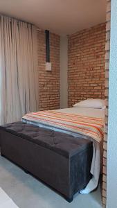 ein großes Bett in einem Zimmer mit Ziegelwand in der Unterkunft Casa Lounge Relax in Touros