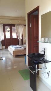 ein Badezimmer mit einem Waschbecken und ein Schlafzimmer mit einem Bett in der Unterkunft Three Ayu Family House in Ubud