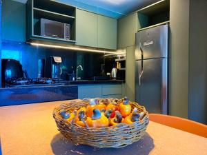 un panier d'oranges assis sur une table dans une cuisine dans l'établissement Flat bijupira exclusive brisa do mar em Porto de galinhas a 100 metros das piscinas naturais, à Porto de Galinhas