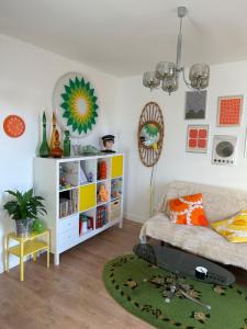 ein Wohnzimmer mit einer Couch und einem Bücherregal in der Unterkunft Le vintage, 10 min de Disneyland, 30 min de Paris - 50 m gare- 30 min CDG aéroport in Esbly