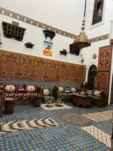 Una sala de estar con sofás y una lámpara de araña. en Riad Dar Bahja - More Than a Stay, en Fez