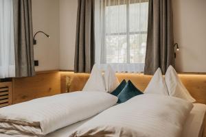 a bedroom with two beds and a window at Miraval Perathoner Andreas in Ortisei