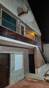a building with a balcony and a white sign on it at Ginjals-67 Quarto Branco in Almargem do Bispo