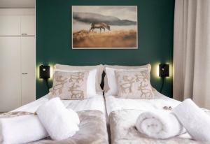 ein Schlafzimmer mit zwei Betten mit weißen Laken und einem Bild eines Hirsches in der Unterkunft Reindeer Dream Suite - Central Rovaniemi in Rovaniemi