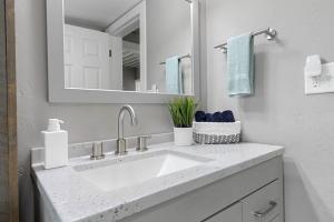 een witte badkamer met een wastafel en een spiegel bij Lazy River Villa - Hottub! Fenced Yard! Fire Pit! in Oconto +43 foto's