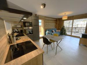 a kitchen and living room with a table and chairs at Appartement Haut de Gamme neuf avec deux terrasses - 6 personnes - App 102 in Saint-Sorlin-dʼArves