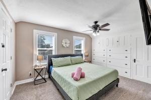 een slaapkamer met een bed en een plafondventilator bij Lazy River Villa - Hottub! Fenced Yard! Fire Pit! in Oconto