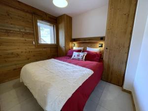 a bedroom with a large bed with red and white sheets at Appartement Haut de Gamme neuf avec deux terrasses - 6 personnes - App 102 in Saint-Sorlin-dʼArves