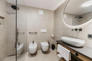 a bathroom with a sink and a toilet and a mirror at Miraval Perathoner Andreas in Ortisei +13 photos