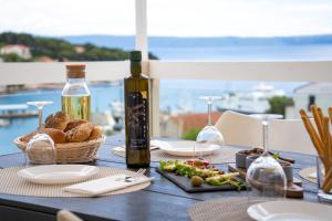 a table with a bottle of wine and a basket of food at Apartment Darka 1 in Sumartin