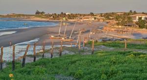 una playa con barcos en la arena y el agua en Paraíso dos Coqueiros, en Fortim