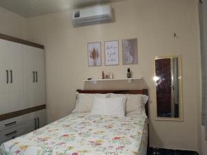 Un dormitorio con una cama con una colcha floral. en Paraíso dos Coqueiros, en Fortim