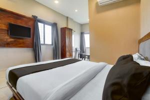 a bedroom with a bed and a tv on the wall at Hotel O Maharashtra Darbar Gonde in Pādli